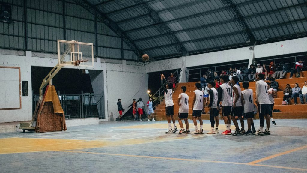 A group of men standing around a basketball court