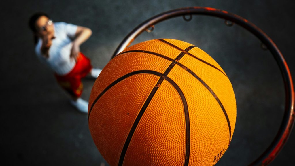 a person standing next to a basketball hoop