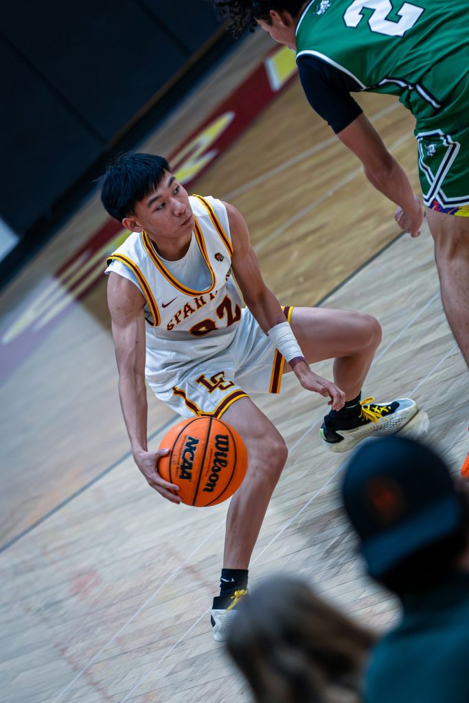 A basketball player dribbles the ball on the court.