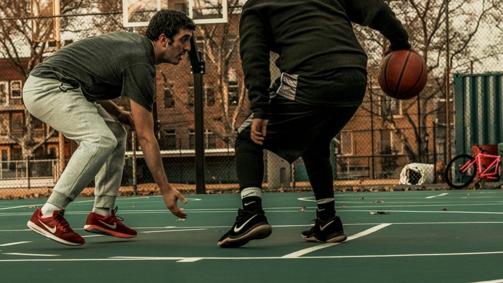 man in black jacket and black pants playing basketball